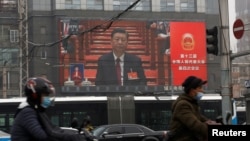 A giant screen shows Chinese President Xi Jinping attending the opening session of the National People's Congress (NPC) at the Great Hall of the People, in Beijing, China March 5, 2021. (REUTERS/Tingshu Wang)