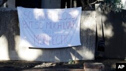 A sign is placed on a fence in the aftermath of a devastating mudslide, Jan. 13, 2018, in Montecito, Calif.