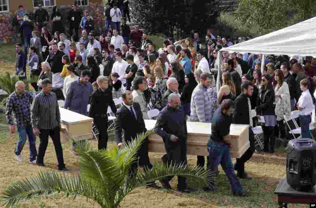 Men carry the remains of Dawna Ray Langford, 43, and her sons Trevor, 11, and Rogan, 2, who were killed by drug cartel gunmen, before they are buried at the cemetery in La Mora, Sonora state, Mexico.