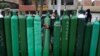 Edgar Barbaran exchanges a small, empty oxygen tank for a large one as he waits since the previous day for a refill shop to open in Callao, Peru, amid the COVID-19 pandemic.