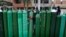 Edgar Barbaran exchanges a small, empty oxygen tank for a large one as he waits since the previous day for a refill shop to open in Callao, Peru, amid the COVID-19 pandemic.
