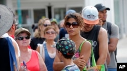 People wait in line to withdraw cash at a bank in the aftermath of Hurricane Maria, in San Juan, Puerto Rico, Sept. 27, 2017.