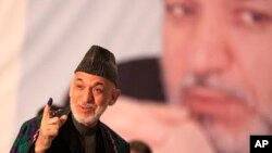 Tổng thống Afghanistan Hamid Karzai đi bỏ phiếu tại trường trung học Amani, gần dinh tổng thống ở thủ đô Kabul, Afghanistan, ngày 5/4/2014.