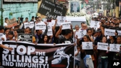 Protesters and supporters carry banners and placards as they march with the hearse of slain Kian Loyd Delos Santos, a 17-year-old student, during his funeral, Aug. 26, 2017, in suburban Caloocan city north of Manila, Philippines. The killing of Kian has sparked an outcry against President Rodrigo Duterte's anti-drug crackdown.