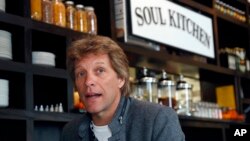 FILE- In this Oct. 19, 2011, file photo, rock star Jon Bon Jovi sits in his JBJ Soul Kitchen community restaurant in Red Bank, N.J. The restaurant is providing free meals to local government workers and their families during the federal government shutdow