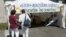 FILE - Two women stand in front of an information stand raising awareness against sexual assault and street harassment during the 81st Bayonne Festival (Fetes de Bayonne) in Bayonne, southwestern France, July 27, 2017.