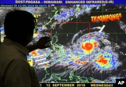 Forecaster Meno Mendoza shows the path of Super Typhoon Mangkhut, locally named "Typhoon Ompong," as it approaches the Philippines at the Philippine Atmospheric, Geophysical and Astronomical Services Administration in Manila, Sept. 12, 2018.