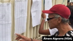 En la foto, ciudadanos revisan el listado de inscripción de documentos, en colegios electorales dispuestos para las elecciones regionales.