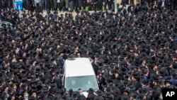 Ribuan warga Yahudi ultra-Ortodoks menghadiri prosesi pemakaman rabi terkemuka Meshulam Soloveitchik, di Yerusalem, mengabaikan aturan lockdown, Minggu, 31 Januari 2021.