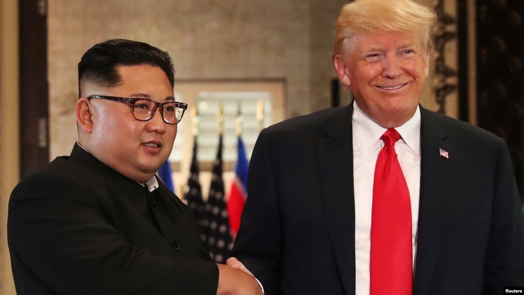 Tổng thống Mỹ Donald Trump và lãnh tụ Triều Tiên Kim Jong Un bắt tay sau khi ký tuyên bố chung, 12/6/2018.