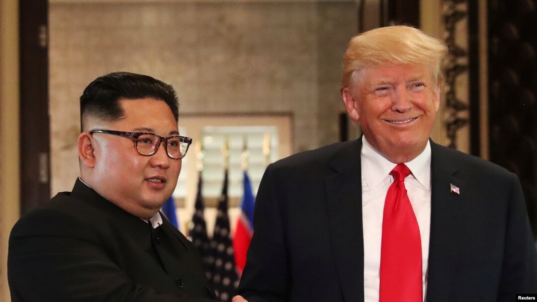 Presiden AS Donald Trump dan pemimpin Korea Utara Kim Jong Un berjabat tangan setelah menandatangani dokumen dalam pertemuan puncak di Hotel Capella, Pulau Sentosa, Singapura, 12 Juni 2018.