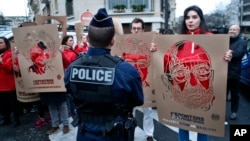 FILE - Members of Reporters Without Borders hold stencils representing portraits of detained Turkish journalists, during a demonstration in front of the Turkish embassy, in Paris, Jan. 5, 2018. (AP Photo/Thibault Camus) 