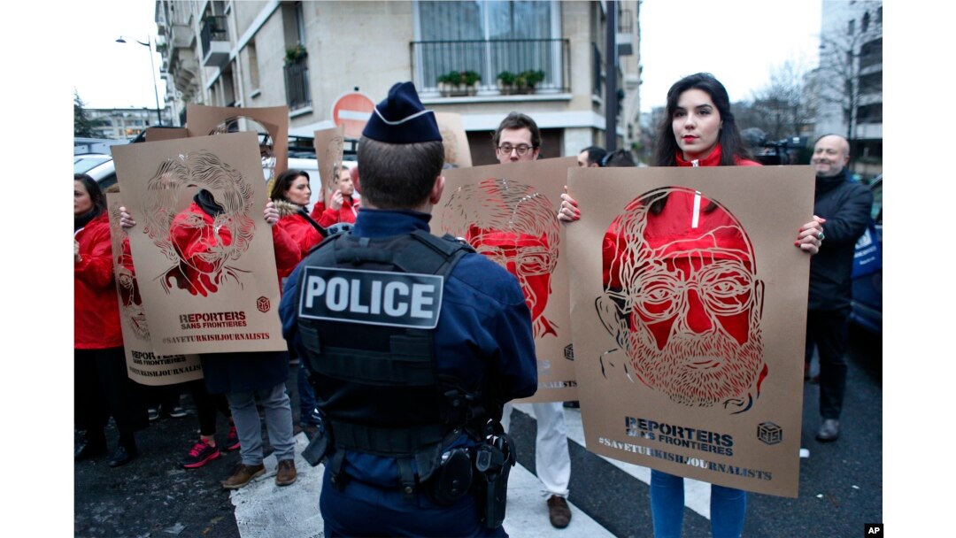 Para anggota Wartawan Tanpa Tapal Batas memegang poster dengan gambar para wartawan Turki yang ditahan, dalam unjuk rasa di depan Kedutaan Besar Turki di Paris, 5 Januari 2018.