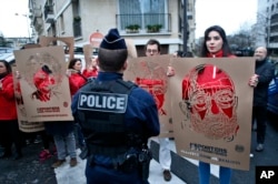 Para anggota Wartawan Tanpa Tapal Batas memegang poster dengan gambar para wartawan Turki yang ditahan, dalam unjuk rasa di depan Kedutaan Besar Turki di Paris, 5 Januari 2018.