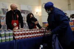 New York Governor Kathy Hochul and Cardinal Timothy Dolan hand out free food supplies at a food distribution event held by the Catholic Charities of the Archdiocese of New York ahead of the Thanksgiving holiday in New York,Nov. 23, 2021