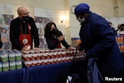 New York Governor Cathy Hochul and Cardinal Timothy Dolan hand out free food supplies at a food distribution event organized by Catholic Charities of the Archdiocese of New York ahead of the Thanksgiving holiday in the Harlem section of Manhattan in New York City.