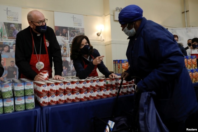 New York Governor Kathy Hochul and Cardinal Timothy Dolan hand out free food supplies at a food distribution event held by the Catholic Charities of the Archdiocese of New York ahead of the Thanksgiving holiday in New York,Nov. 23, 2021