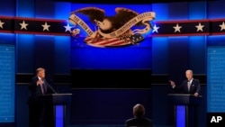 President Donald Trump, left, and Democratic presidential candidate former Vice President Joe Biden, right, with moderator Chris Wallace, center, of Fox News during the first presidential debate, Sept. 29, 2020 in Cleveland, Ohio.