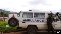 Un soldat Cameroun, à droite, se tient à côté d'une ambulance utilisée pour transporter les victimes du déraillement d'un train vendredi à Eseka, Cameroun, 22 octobre 2016. 