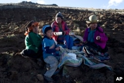 The Pacco family eats dinner after harvesting potatoes in Paru Paru, in the Cusco region of Peru, May 26, 2016.