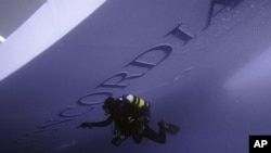 A Carabinieri scuba diver inspects the Costa Concordia cruise ship which ran aground off the west coast of Italy at Giglio island January 19, 2012.