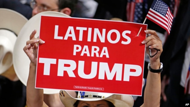 FILE - A woman holds a sign reading in English, "Latinos For Trump" at the Republican National Convention in Cleveland, Ohio.