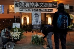FILE - People attend a vigil for Dr. Li Wenliang, in Hong Kong, Feb. 7, 2020.