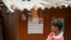 FILE - A boy looks at a calendar with a portrait of India's Prime Minister Narendra Modi in Tatem village some 43 Km (27 miles) from Dantewada town in Chhattisgarh state on April 16, 2024.