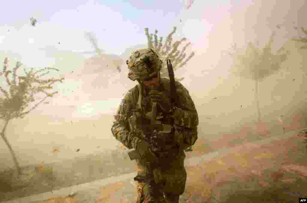 Sept. 15: 2nd Lt. Andrew Ferrara, with the U.S. Army's the 25th Infantry Division, next to the rotor wash of a landing Blackhawk helicopter during a mission for a key leader engagement in Kunar province, Afghanistan. (AP Photo/David Goldman)