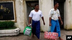 Dua tahanan politik Burma berjalan keluar dari penjara Insein di Yangon (Rangun), Burma, setelah mendapatkan amnesti dari Presiden Thein Sein, Selasa (23/7).