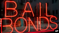 FILE - In this July 7, 2015, file photo, a sign advertising a bail bonds business is displayed near Brooklyn's jail and courthouse complex in New York. 