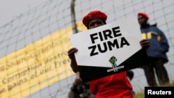 FILE - Supporters of various opposition parties hold placards calling for the removal of President Jacob Zuma outside the Constitutional Court in Johannesburg, South Africa, May 15, 2017.