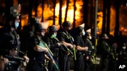 FILE - In this March 24, 2021, file photo, Los Angeles police officers move in to arrest demonstrators in the Echo Park Lake homeless encampment in Los Angeles. 