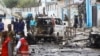 Security officers gather at the scene of a suicide car bombing at a street junction near the president's residence, in Mogadishu, Somalia, Sept. 25, 2021.