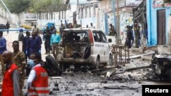 Security officers gather at the scene of a suicide car bombing at a street junction near the president's residence, in Mogadishu, Somalia, Sept. 25, 2021.