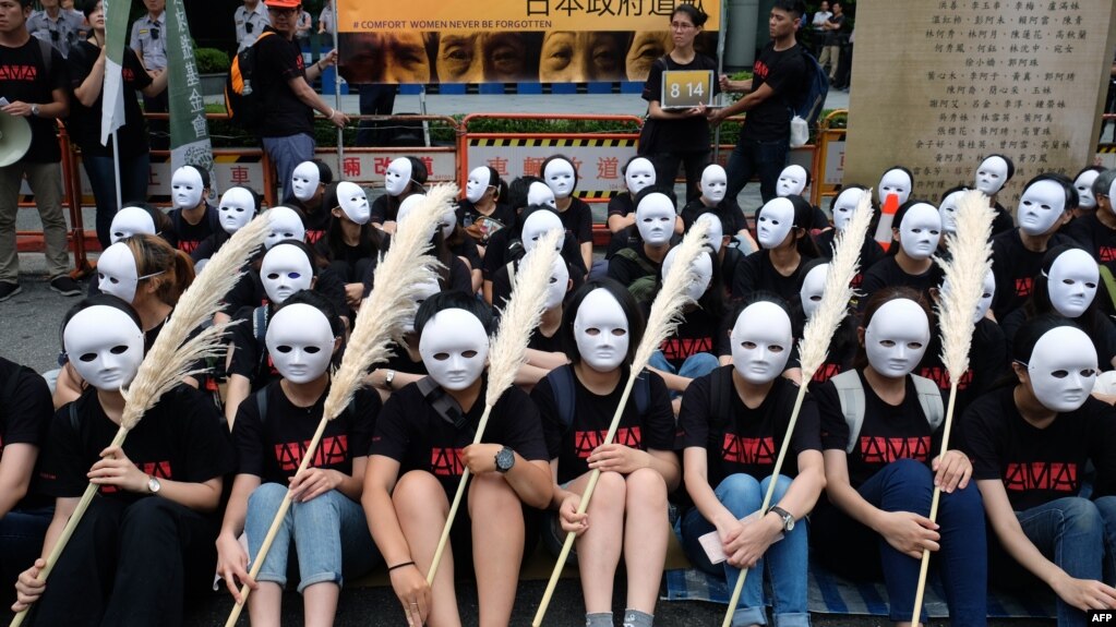 Taiwanese NGO group members wear masks during a rally to demand that the Japanese government apologize to Taiwanese "comfort women" in Taipei on Aug. 14, 2018.