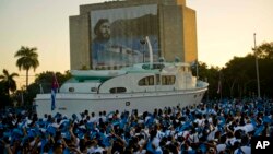 Estudiantes cubanos asisten al desfile militar del lunes 2 de enero en honor del desaparecido líder Fidel Castro, junto a una réplica del yate Granma en la Plaza de la Revolución de La Habana.