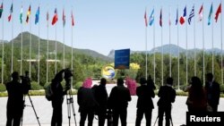 FILE - Journalist take pictures outside the venue of a summit at the Belt and Road Forum in Beijing, China, May 15, 2017. 