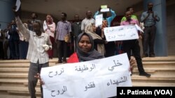 Susana Abdalla Hassan, an employee of Bank of Khartoum, holds a sign supporting the revolution while striking outside Al-Waha mall, in Khartoum, Sudan, May 28, 2019.
