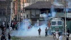 FILE - Kashmiri demonstrators throw stones towards Indian security forces during a clash following the death of Syed Ali Shah Geelani, a Kashmiri veteran separatist politician, in Srinagar, September 2, 2021.