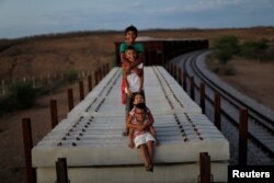Raniel da Silva, Ariel da Silva, Ariana da Silva and Daniel da Silva pose for a portrait on the top of a train wagon near the city of Salgueiro, Pernambuco state, northeastern Brazil, Oct. 26, 2016.
