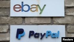 FILE - Signs are posted outside the offices of online marketplace eBay and its electronic payments division PayPal in Toronto, Canada.