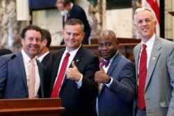 Sens. David Parker, R-Olive Branch, left, Chad McMahan, R-Guntown, Derrick Simmons, D-Greenville, second from right, and David Blount, D-Jackson, right, strike a congratulatory pose after the Senate voted to change the Mississippi state flag.