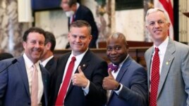 Sens. David Parker, R-Olive Branch, left, Chad McMahan, R-Guntown, Derrick Simmons, D-Greenville, second from right, and David Blount, D-Jackson, right, strike a congratulatory pose after the Senate voted to change the Mississippi state flag.