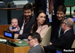 New Zealand Prime Minister Jacinda Ardern sits with her baby Neve