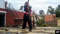 Seorang petugas keamanan berjaga di dekat lokasi serangan bom di Ghalanai, Pakistan, 15 Februari 2017 (AP Photo/Alamgir Khan).