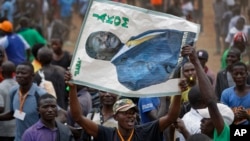 A supporter of Kenyan opposition leader Raila Odinga holds a banner of him with the Swahili words "Father" and "Chairman" at a rally in the Shauri Moyo area of Nairobi, Kenya, Oct. 18, 2017.