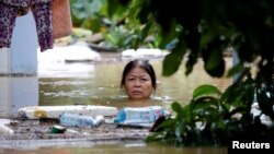 Một phụ nữ lội trên một con đường ngập nước tại khu phố cổ Hội An, được UNESCO công nhận là di sản văn hóa thế giới, sau khi bão Damrey ập vào Việt Nam hôm 6/11/2017. REUTERS/Kham