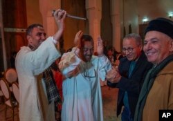 FILE—People sprinkle orange blossom water after it was distilled, in a cultural center in Marrakech, Morocco, March 23, 2024.