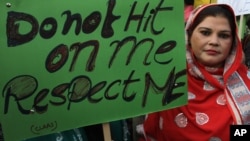 FILE - Pakistani woman holds a sign as she observes the International Day for the Elimination of Violence against Women, in Lahore, Pakistan, Nov. 25, 2015. 